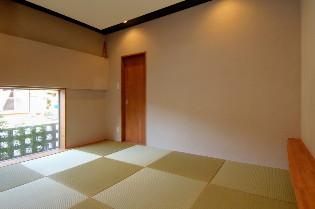 シンプル、モダンな和室　天井は高さ、色を変えて変化をつける　壁を照らす照明配置　ナチュラルな扉
