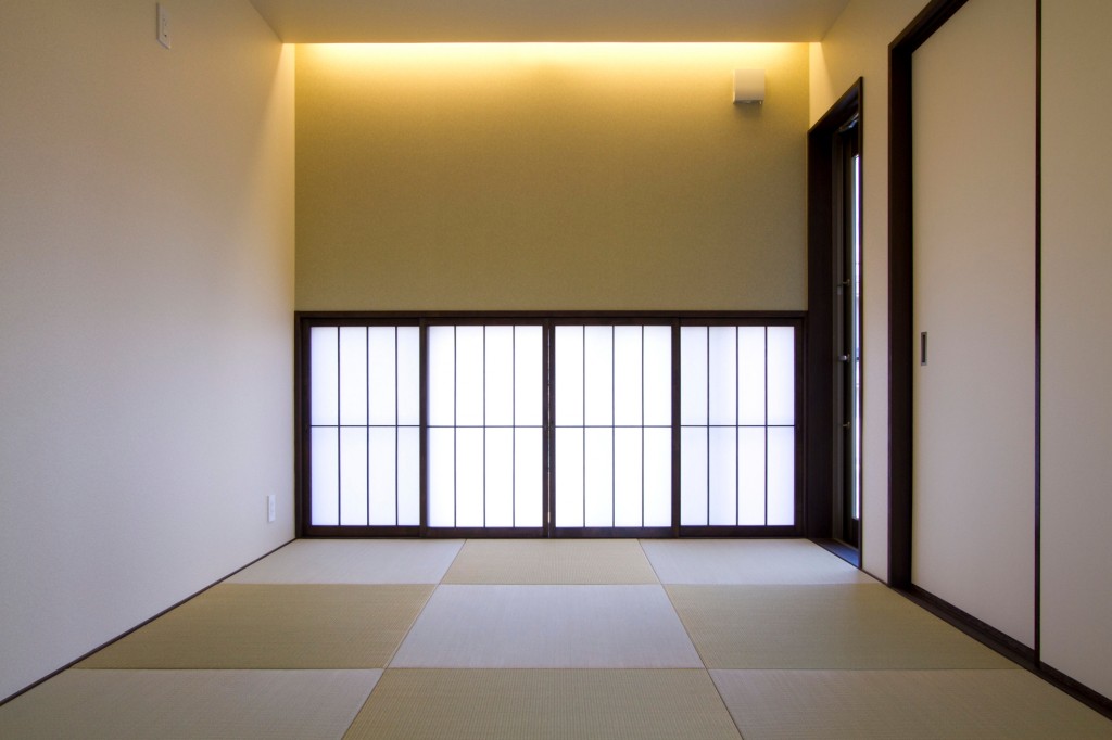シンプルモダンな和室　縁のない半畳の畳　柱を隠した壁　間接照明