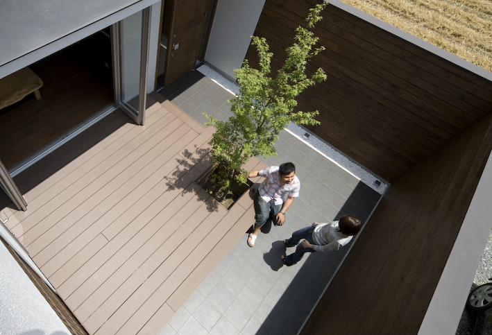 三重県津市　建築家との家づくり　塀で囲われた庭　木樹脂デッキとシンボルツリー